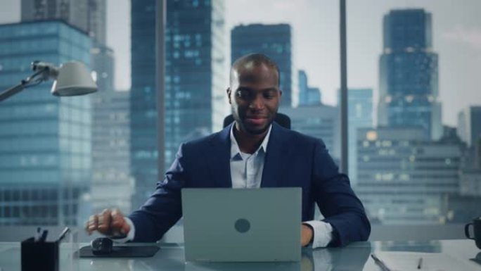 成功的黑人商人在他的大城市办公室里在笔记本电脑上工作的肖像。专业数字企业家为电子商务战略评估做数据分