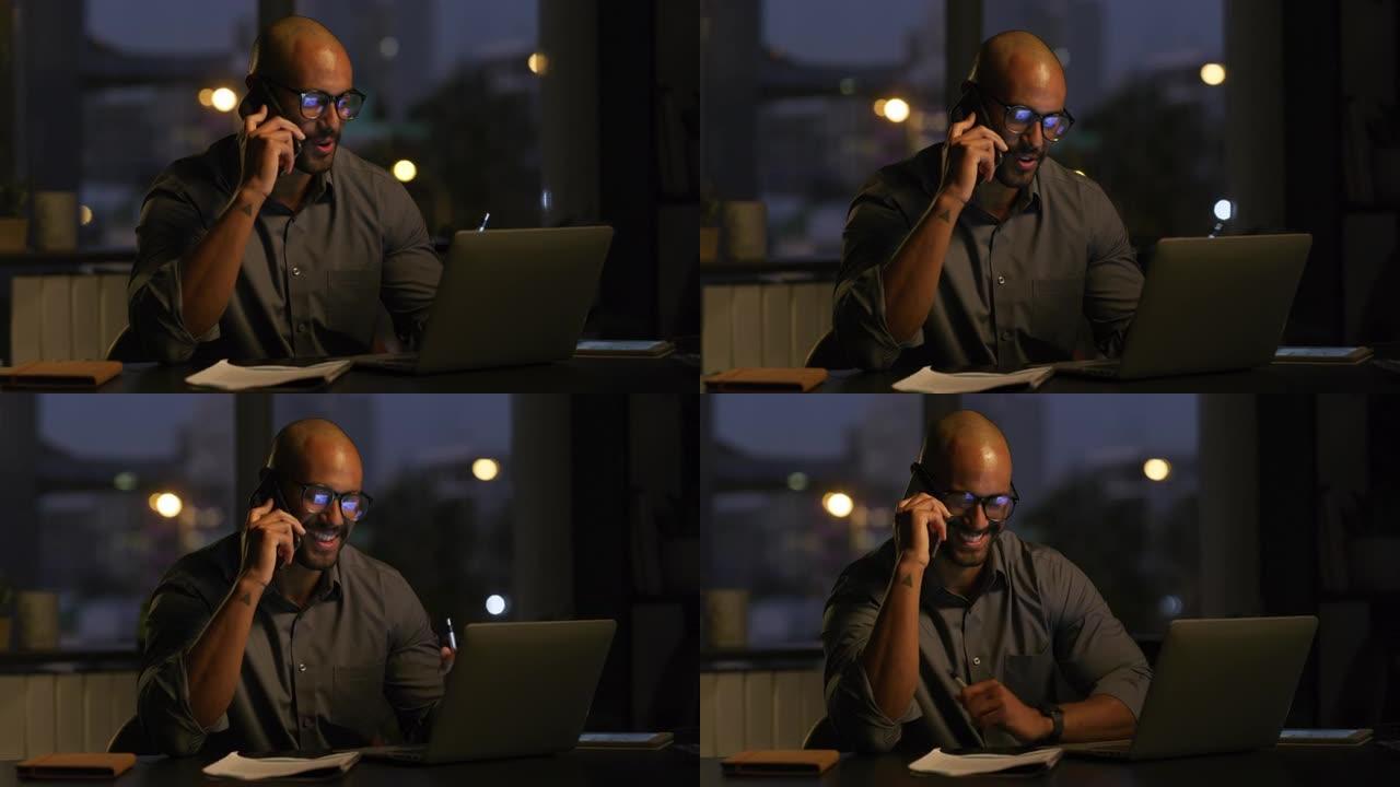4k视频片段，一个英俊的年轻商人晚上独自坐在办公室里使用手机