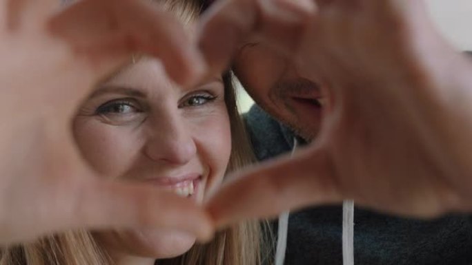 快乐的情侣在情人节4k镜头用手示意浪漫的承诺享受爱情关系