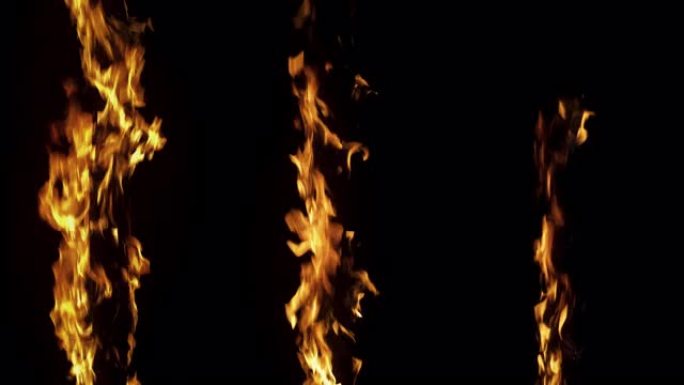 在黑色背景上近距离拍摄慢动作: 三根垂直的木棍着火，在火焰中燃烧。特殊效果、视觉效果、后期制作、动画