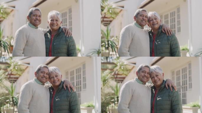 享受退休生活，微笑或幸福的老年夫妇拥抱，持有或拥抱房地产投资者。老年养老金领取者，有良好房屋保险的爱