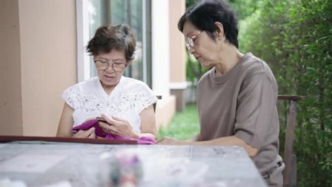 两位高级女性退休有爱好谈论和讨论面料和刺绣