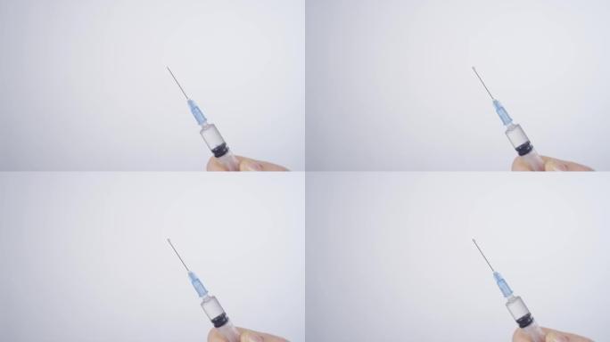 特写: 从注射器中喷出的透明疫苗的详细镜头。
