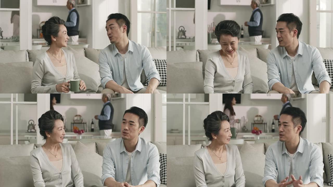 资深亚裔妈妈和成年儿子在家聊天
