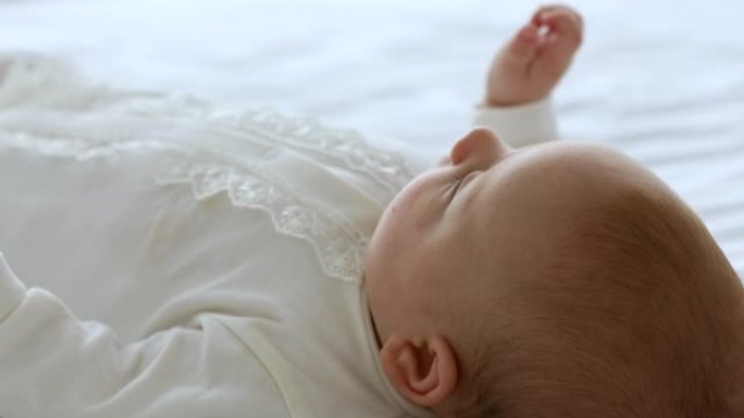 婴儿生长中的活跃小婴儿躺在床上移动双手