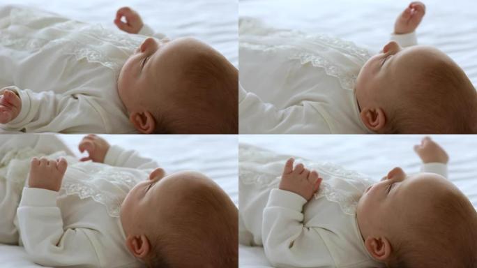 婴儿生长中的活跃小婴儿躺在床上移动双手