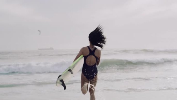4k视频片段，一个无法识别的女人拿着冲浪板奔向大海
