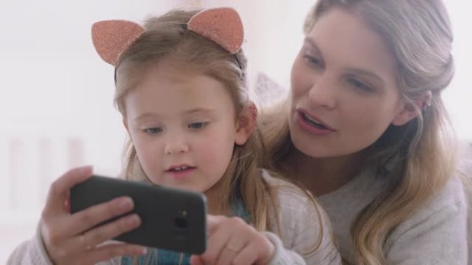 母亲和孩子使用智能手机进行视频聊天小女孩与妈妈挥舞着分享假期周末与女儿享受在手机上聊天4k镜头