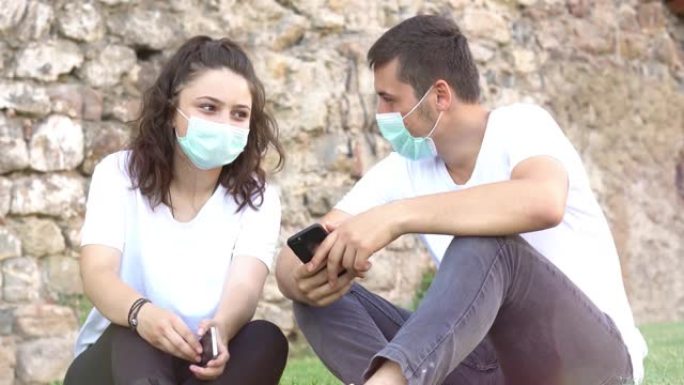 年轻的成年朋友戴着污染面具，以保护自己免受病毒侵害。年轻的朋友在微笑。-新的正常生活方式概念-实时过