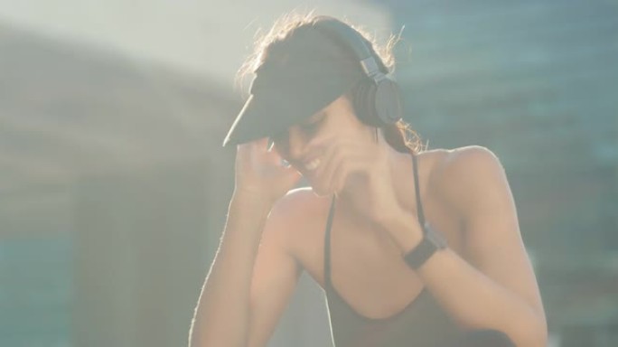 4k视频片段，一名运动的年轻女子坐在外面听音乐