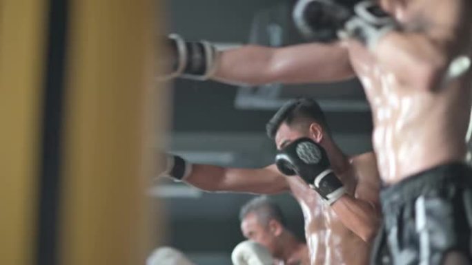低角度3亚洲泰拳运动员连续在健身房练习，每天有打孔箱