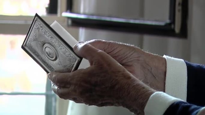 一位老妇人打开带有电话号码索引的笔记本的手。特写。