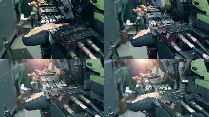 工厂机器正在将胶水涂在鞋底上。鞋类生产设施。