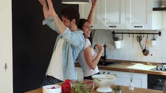 喜出望外的年轻已婚夫妇在厨房跳舞。