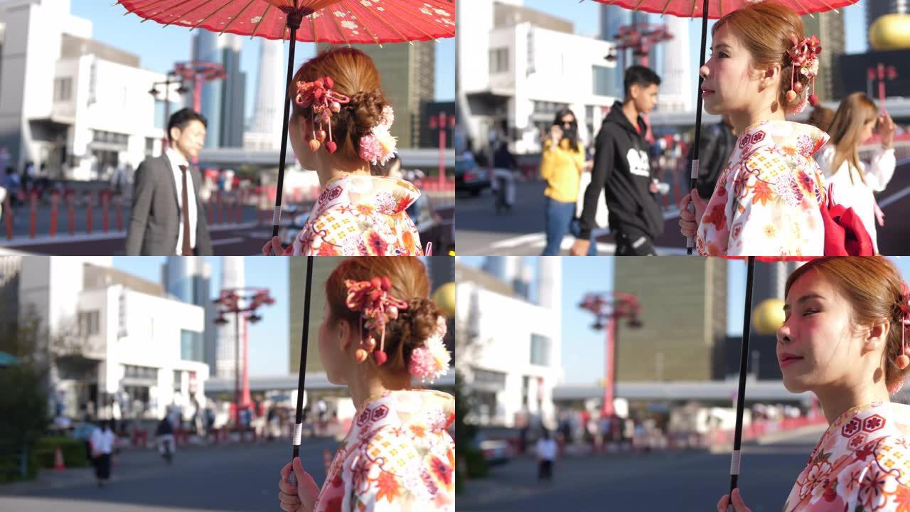 亚洲女子穿着传统日本和服礼服，手持红纸伞