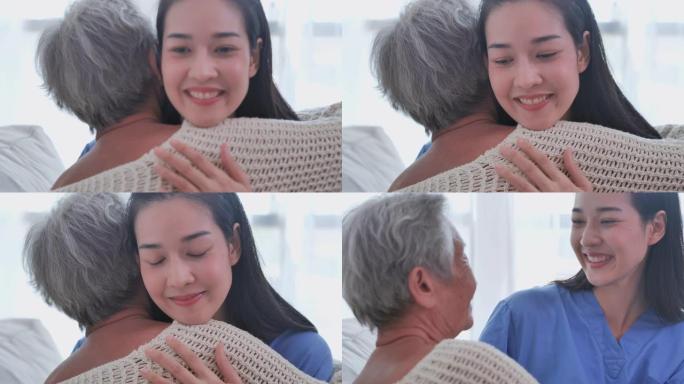 亚洲老年妇女在家里听亚洲年轻女护士医生咨询并拥抱她的老年女病人。在家护理人员