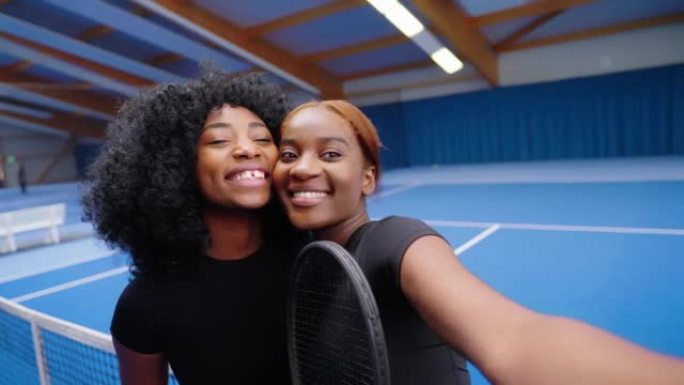 两名女子网球运动员在室内球场上自拍照