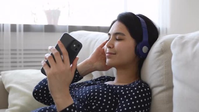 积极的千禧一代越南韩国妇女听音乐。