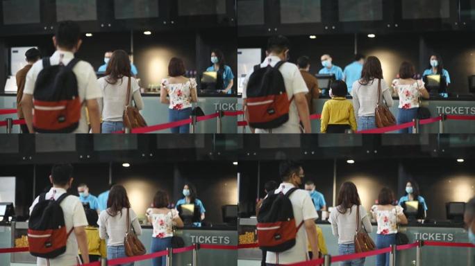 社交距离后视图亚洲华人人群排队等候在电影院购买电影票和小吃新常态练习SOP