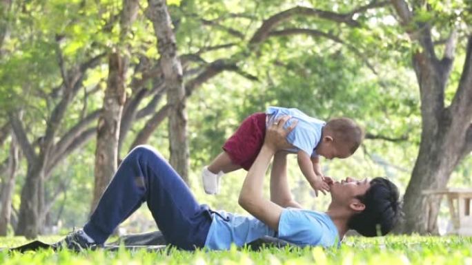 父亲与男婴在公园玩耍，慢动作