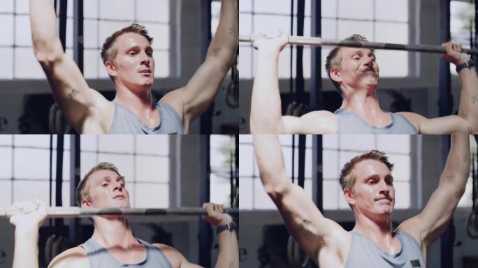 健身男子在健身房做举重运动。肌肉发达的运动员在上半身力量锻炼过程中出汗，并挑战自己以达到耐力目标以增