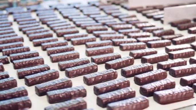 新鲜制作的巧克力糖果棒的输送机运输