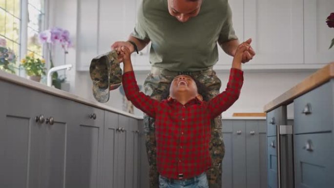 美国军队母亲休假回家，儿子穿着制服在家庭厨房里玩耍-慢动作拍摄
