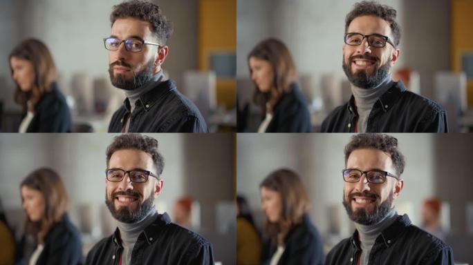 一个英俊聪明的男学生的肖像，在大学学习，在镜头前深情地微笑着。他戴着眼镜，留着胡须和短卷发。在大学里