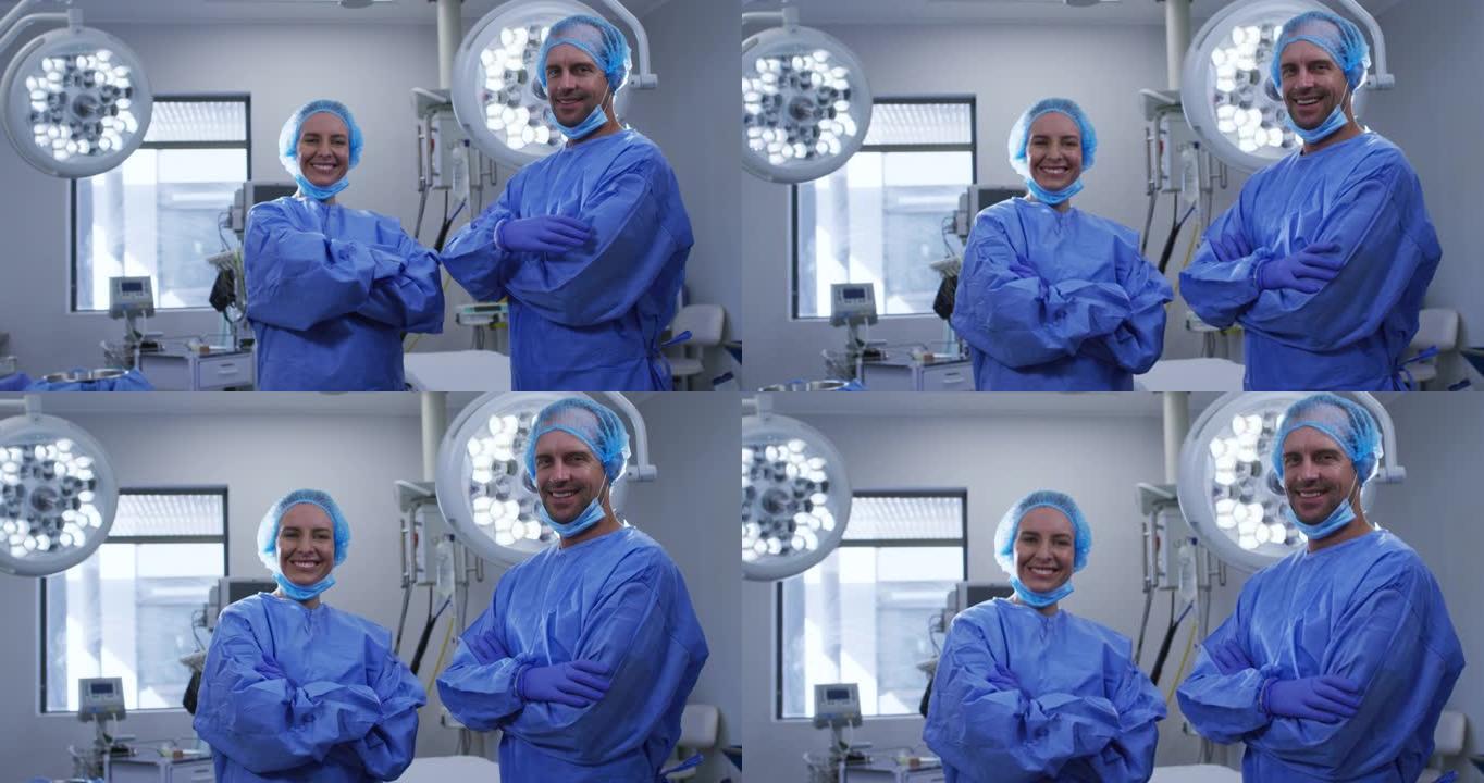 微笑的女性和男性高加索外科医生的肖像，戴着口罩和防护服