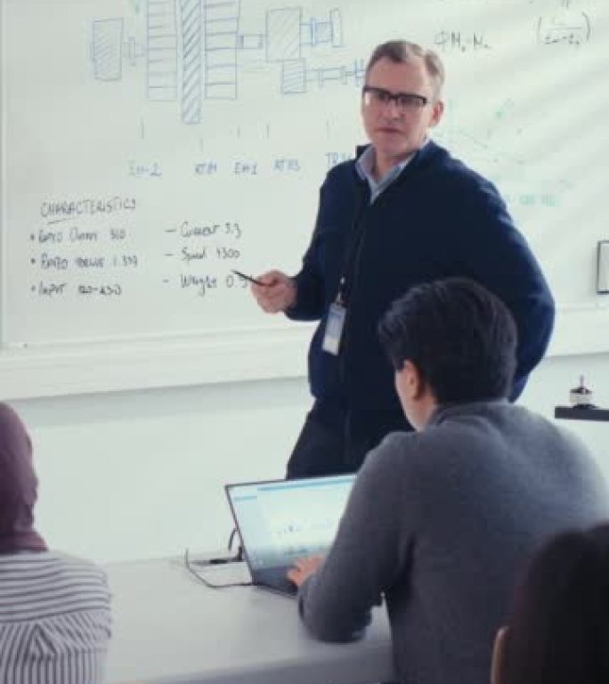 男老师在大学讲座课上向学生讲解工程学。他使用白板。各种各样的年轻工程师听关于程序开发的讲座。教育理念