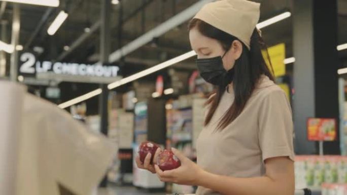 漂亮的年轻女子，戴着医用口罩，在超市里买日用品和杂货。家庭烹饪生活方式