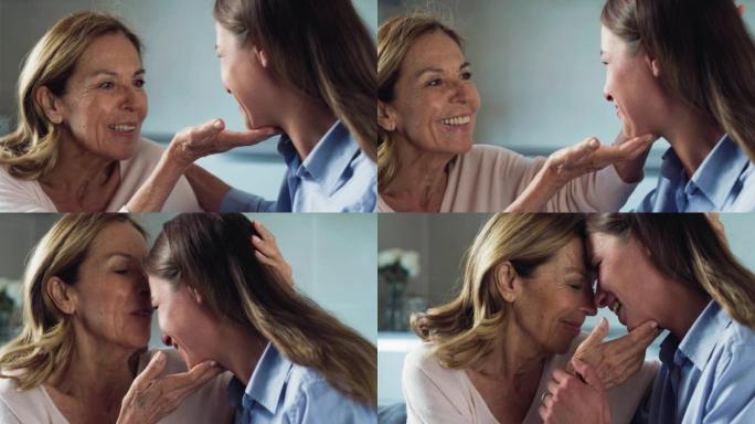 快乐微笑的祖母的电影镜头正在给孙女以情感的拥抱，以示爱与关怀，同时坐在家里的沙发上。概念: 生活，祖