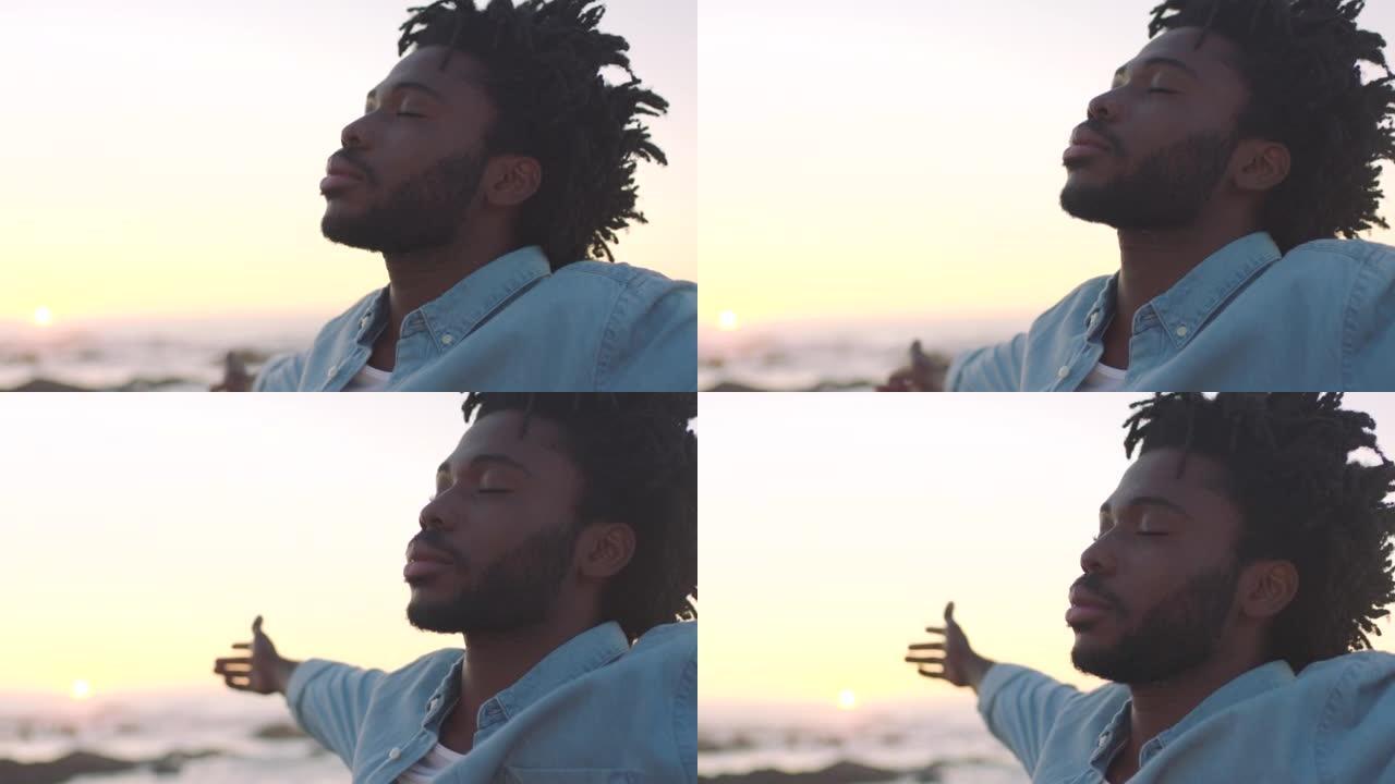 一个非洲裔美国人的特写镜头在日落时发现内心的平静，在一个有复制空间的海滩上宁静而宁静。黑人男性冥想，