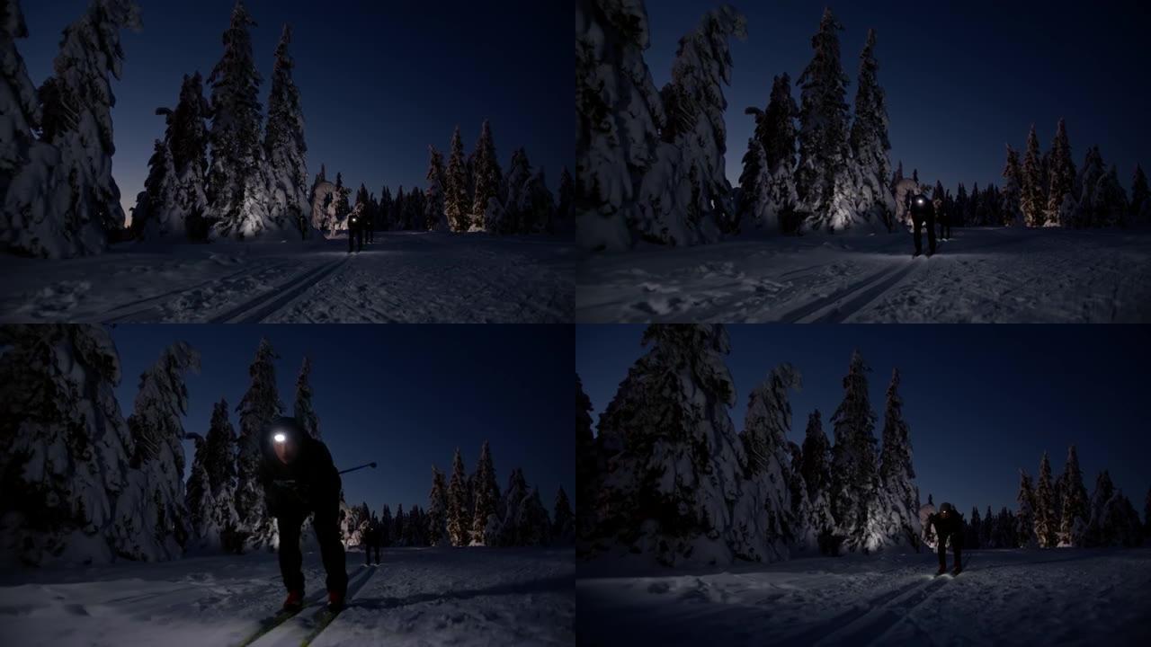 SLO MO越野滑雪者在晚上用大灯滑雪