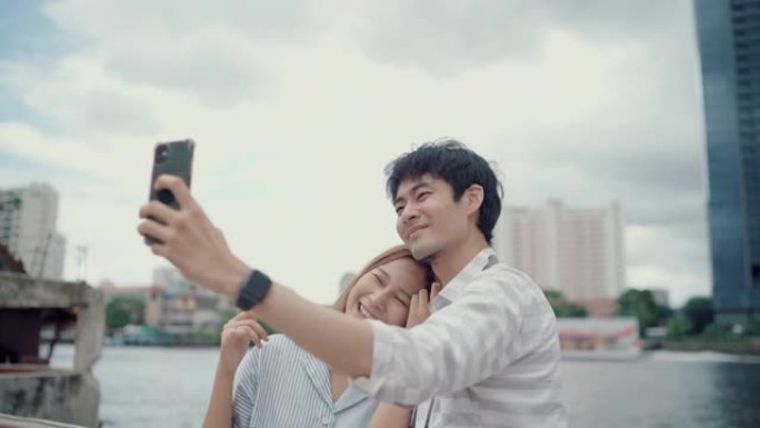 亚洲夫妇在旅行时在智能手机上自拍