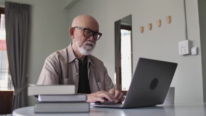 日本高级男子在客厅使用笔记本电脑