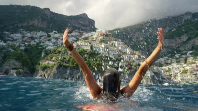 4k视频片段，一名无法识别的妇女在意大利海岸附近的地中海游泳