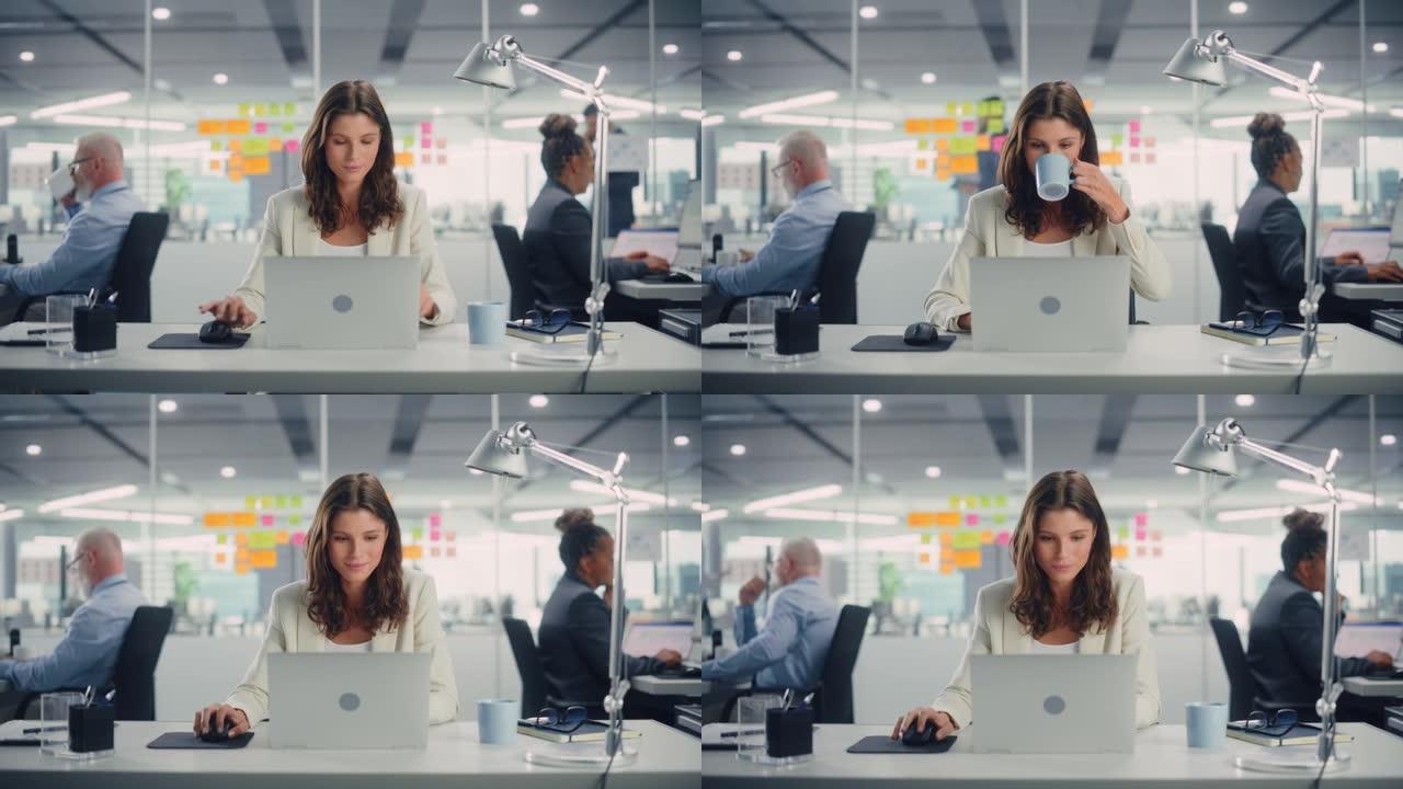 年轻快乐的女商人在现代办公室和同事一起使用电脑。时尚美丽的经理微笑着，从事财务和营销项目。从杯子里喝