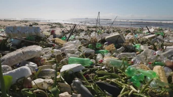 在海滩上冲刷的塑料污染的特写平移视图。对海洋和海洋的环境破坏。