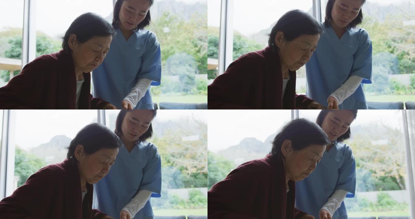 微笑的亚洲女医生帮助高级女患者使用步行框架行走