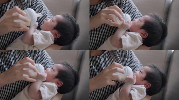 年轻的母亲在怀里给她的新生婴儿喂奶。