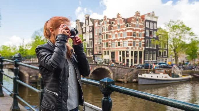 快乐的女人游客在阿姆斯特丹度假，用复古相机拍照