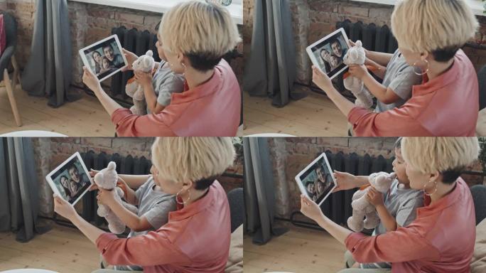 母亲和小儿子与亚洲三口之家视频聊天