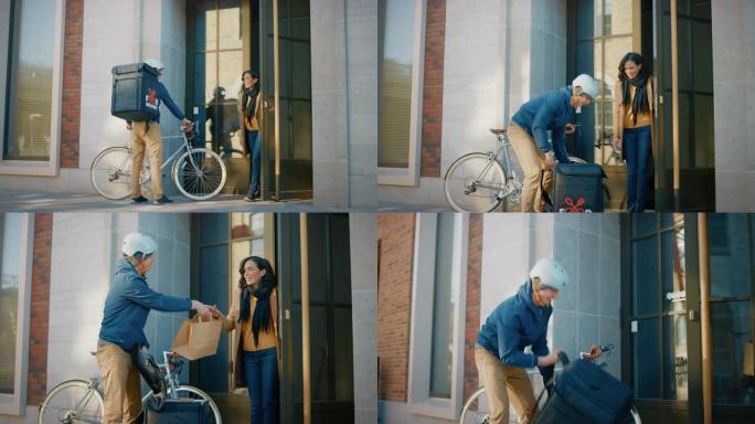 快乐的送餐男子在自行车上穿着保暖背包，向一位美丽的女性顾客提供餐厅订单。快递员在办公楼里给漂亮的女孩
