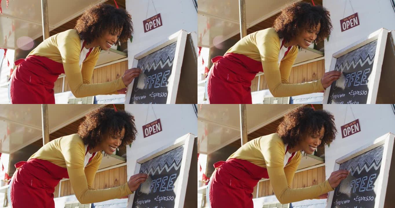 非裔美国妇女穿着围裙在食品菜单上书写餐车的石板上