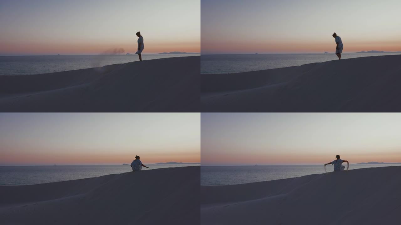 意大利撒丁岛日落时坐在海滩上的女人的景色。