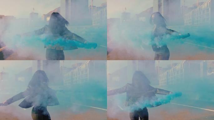 女人在城市与蓝色烟雾弹共舞年轻叛逆女孩在街头慢动作中庆祝创意表达