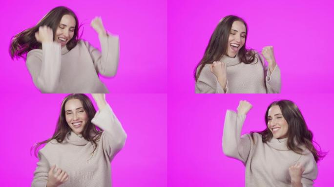 4k视频片段，一位迷人的年轻女子在粉红色的工作室背景下庆祝
