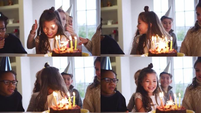 女孩在家里和朋友一起庆祝生日，得到用烟火和蜡烛装饰的蛋糕