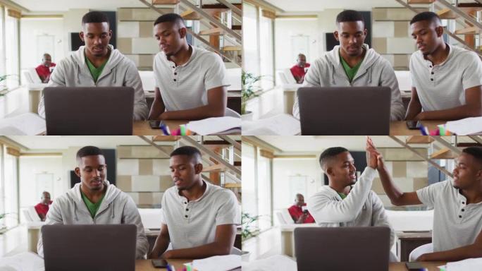 两个非洲裔美国少年双胞胎兄弟使用笔记本电脑并与父亲交谈